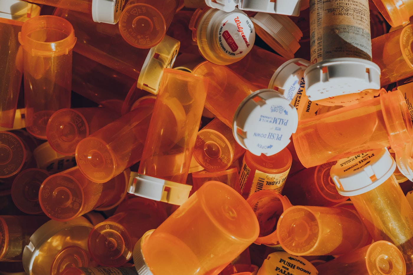 A collection of orange prescription bottles lined up on a shelf.