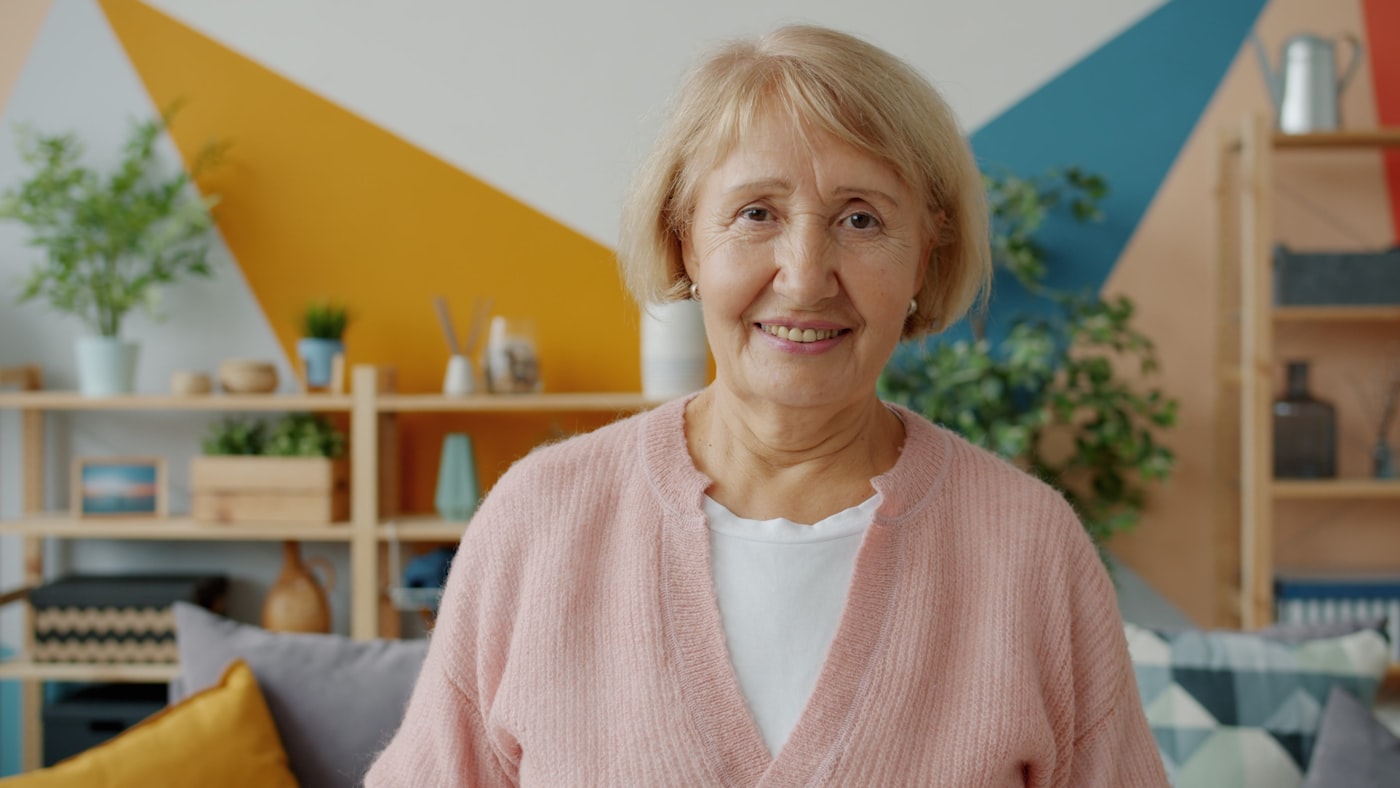 An older adult at ease in a bright, comfortable living space.